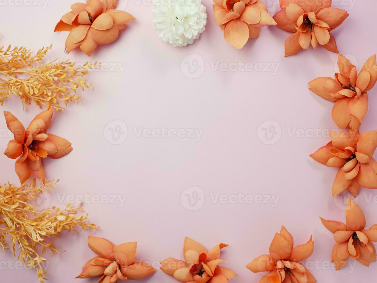 Floral composition. Frame made of orange dry flowers on pastel pink background. Flat lay, top view, copy space photo