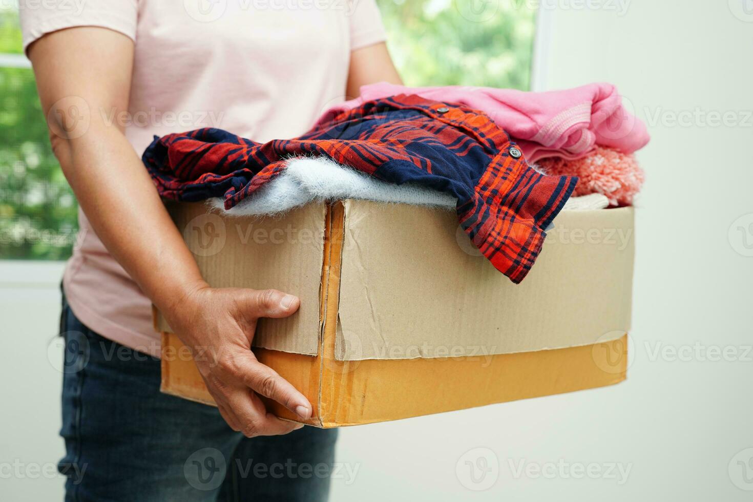 Clothes donations in cardboard box for volunteer. photo