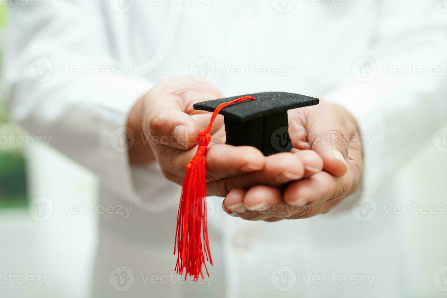 Asian woman doctor holding graduation hat in hospital, Medical education concept. photo