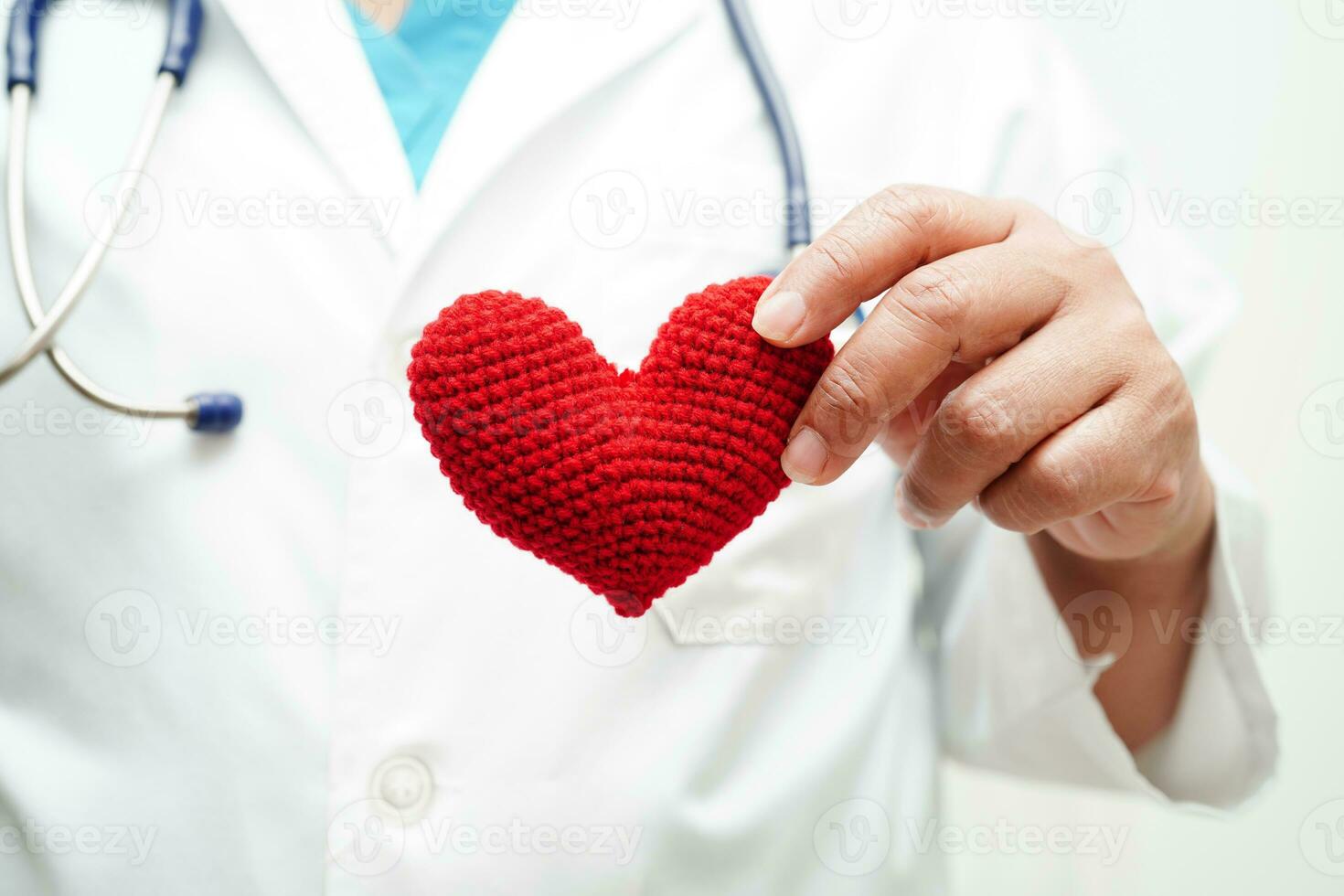 Asian woman doctor holding red heart for health in hospital. photo