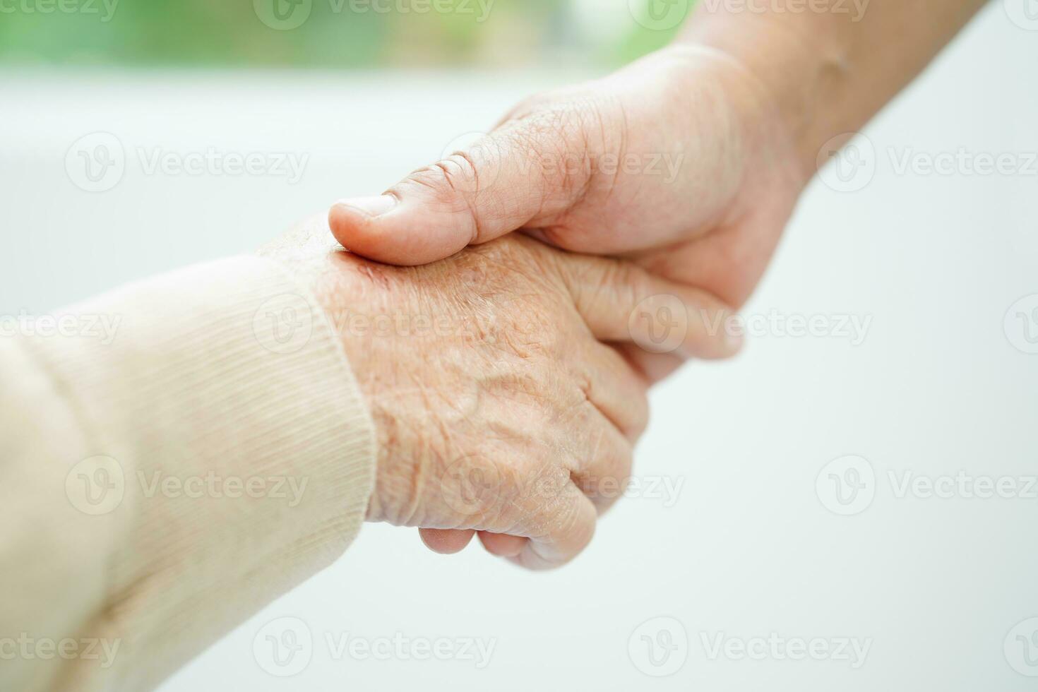 Caregiver holding hands Asian elderly woman patient, help and care in hospital. photo
