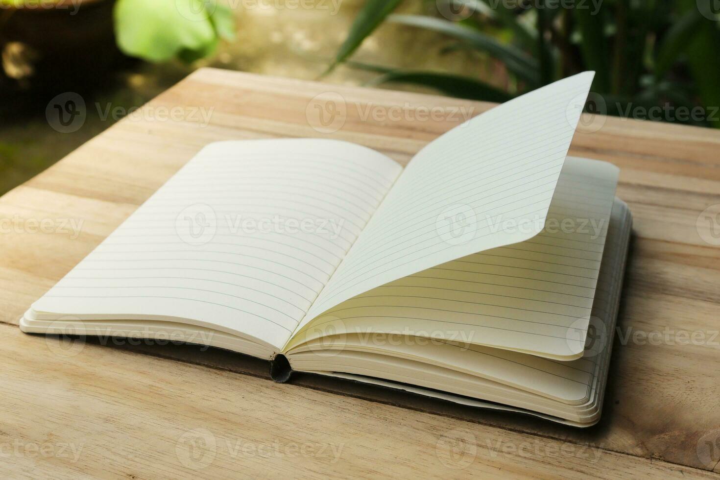 Close up of empty note book on wooden table during the day photo