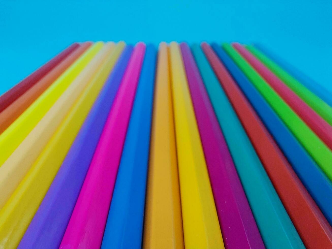 Crayons. Colored Pencils. colored pencils on blue background and wood chips photo