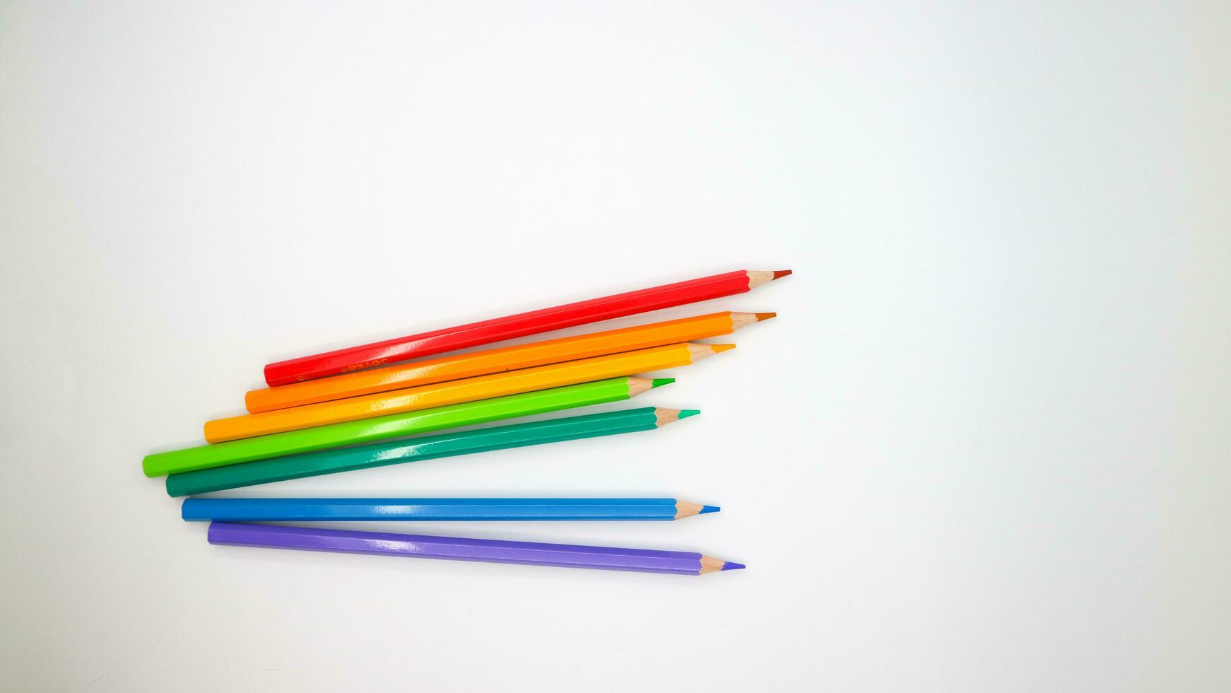 colored pencils in row on a white background top view. photo