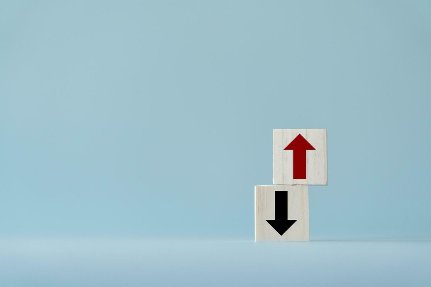 Up and down turn arrow on wooden blocks difference direction to earn or to loss. Red arrow as positive and black as negative movement idea. photo