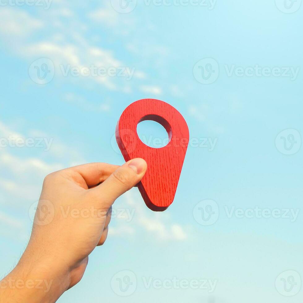 Set location. Red geolocation pin icon in hand. Land market. Tourism and travel. Navigate a route. Location announcement. Gathering place. Business advertising. Transport services. photo