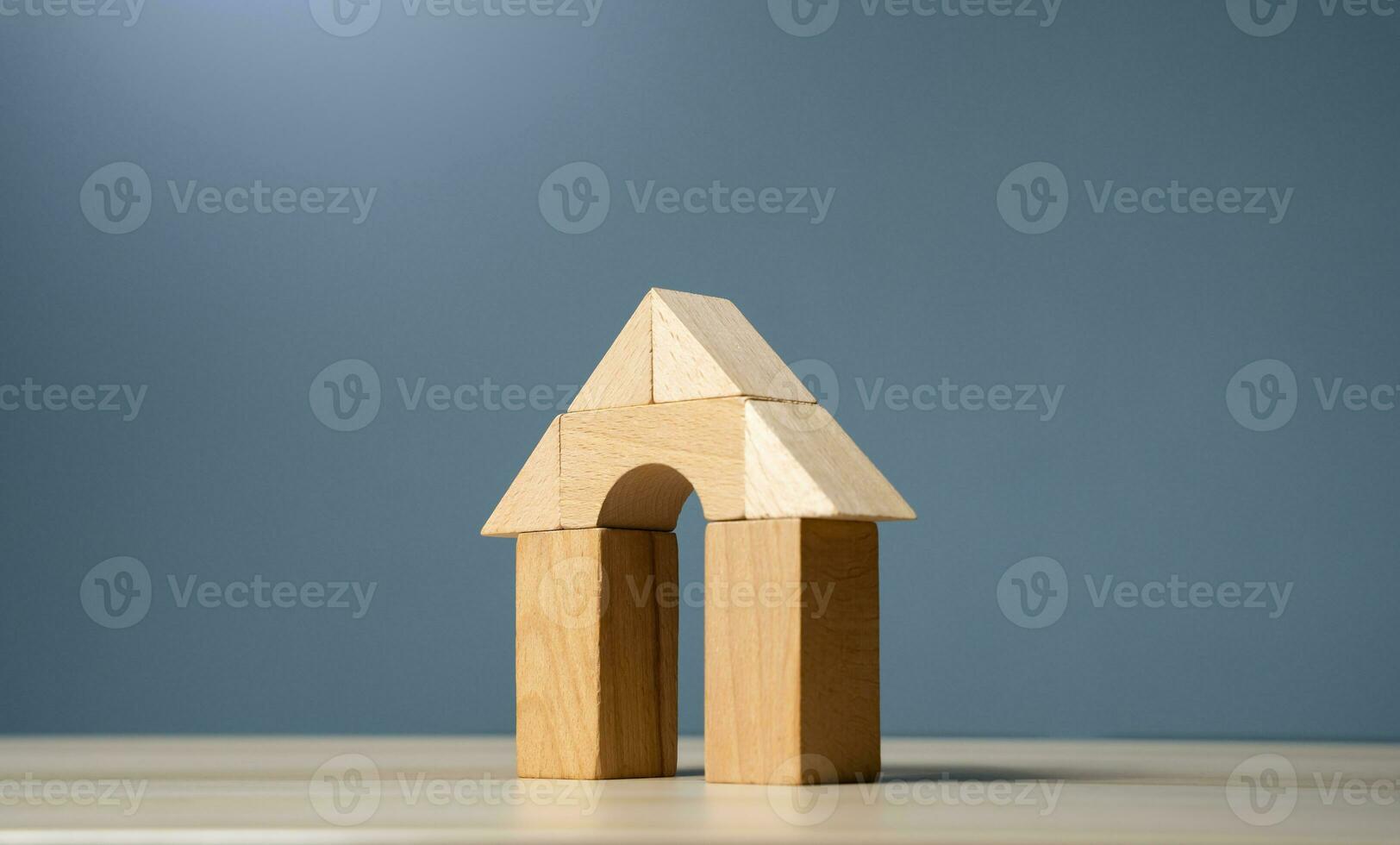 House made of wooden figures on a gray background. Buying and selling housing. Design and architectural services. Real estate market review. Construction industry. Property insurance. photo