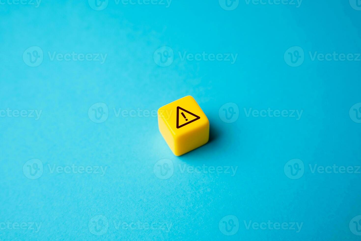 Warning sign on yellow block. Stress, problems. Something wrong. Danger or problem ahead. Careful proceed with caution. Workplace safety. Potential risks. Stress and mental health photo