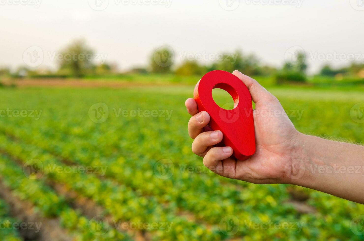 Red location pin on farm field. Buying and selling on land market. Plot Boundary Demarcation service. Legal regulation of property. Agriculture and agribusiness. Land tenure, landownership photo