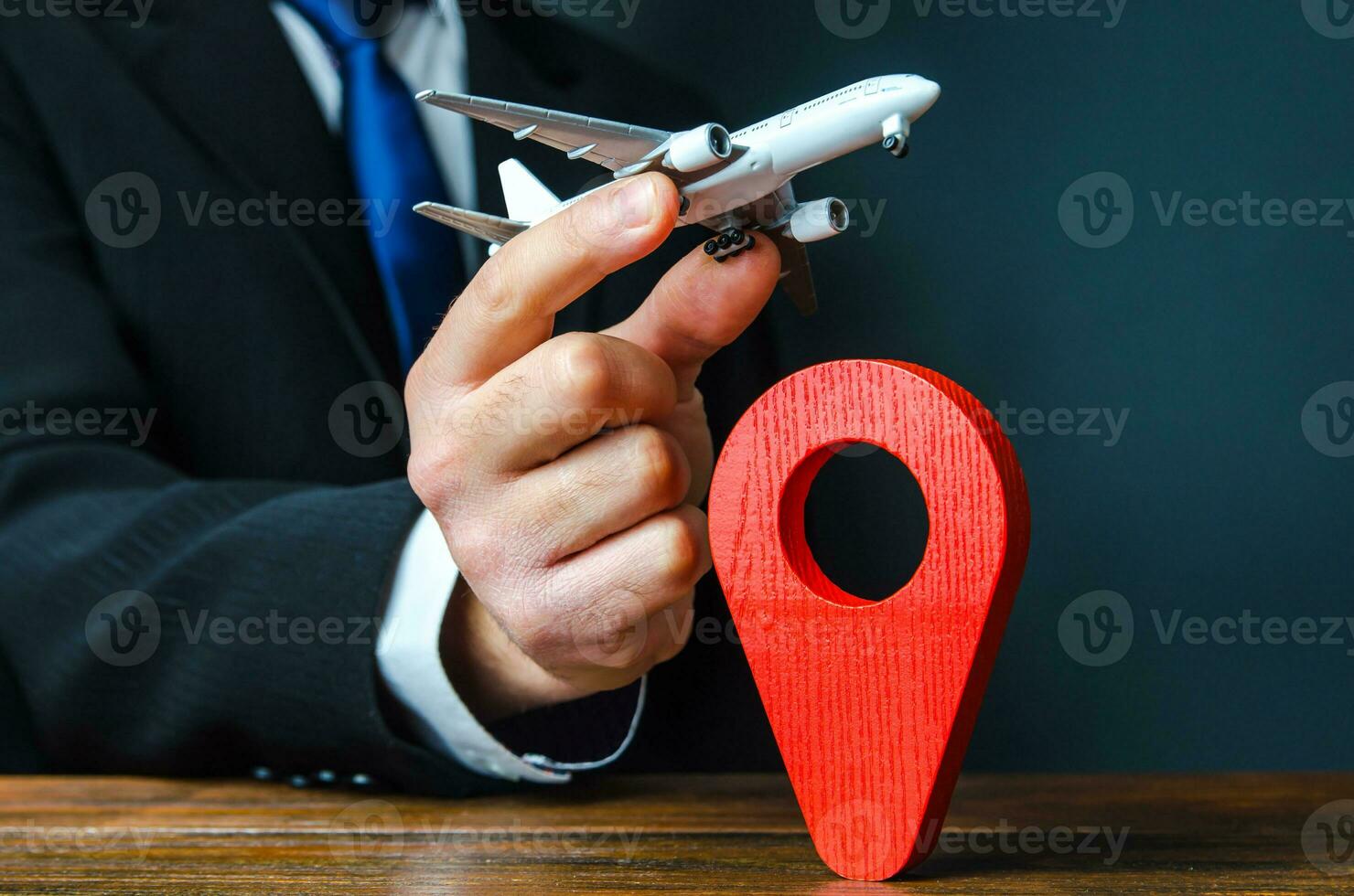 A plane taking off in the hands of a businessman and a pin location symbol. Business tourism. Organization of air traffic. Business class flights. Support financial program for civil aviation photo