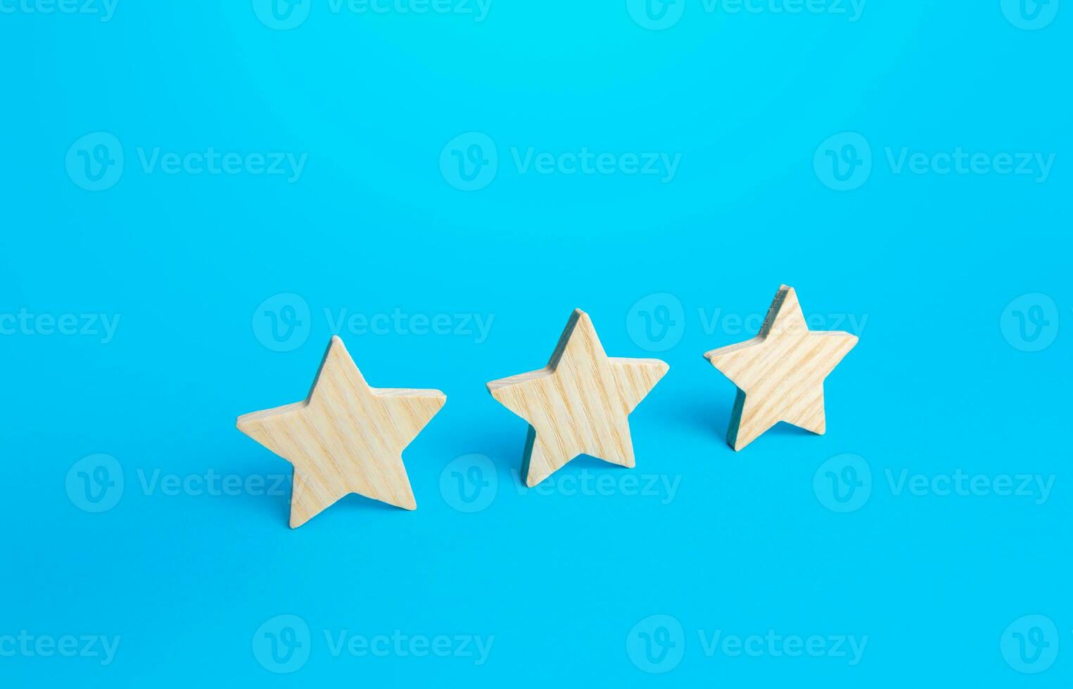 Three stars on a blue background. Rating evaluation concept. Service quality. Buyer feedback. High satisfaction. Popularity rating of a restaurant, hotel or mobile applications. Good reputation status photo