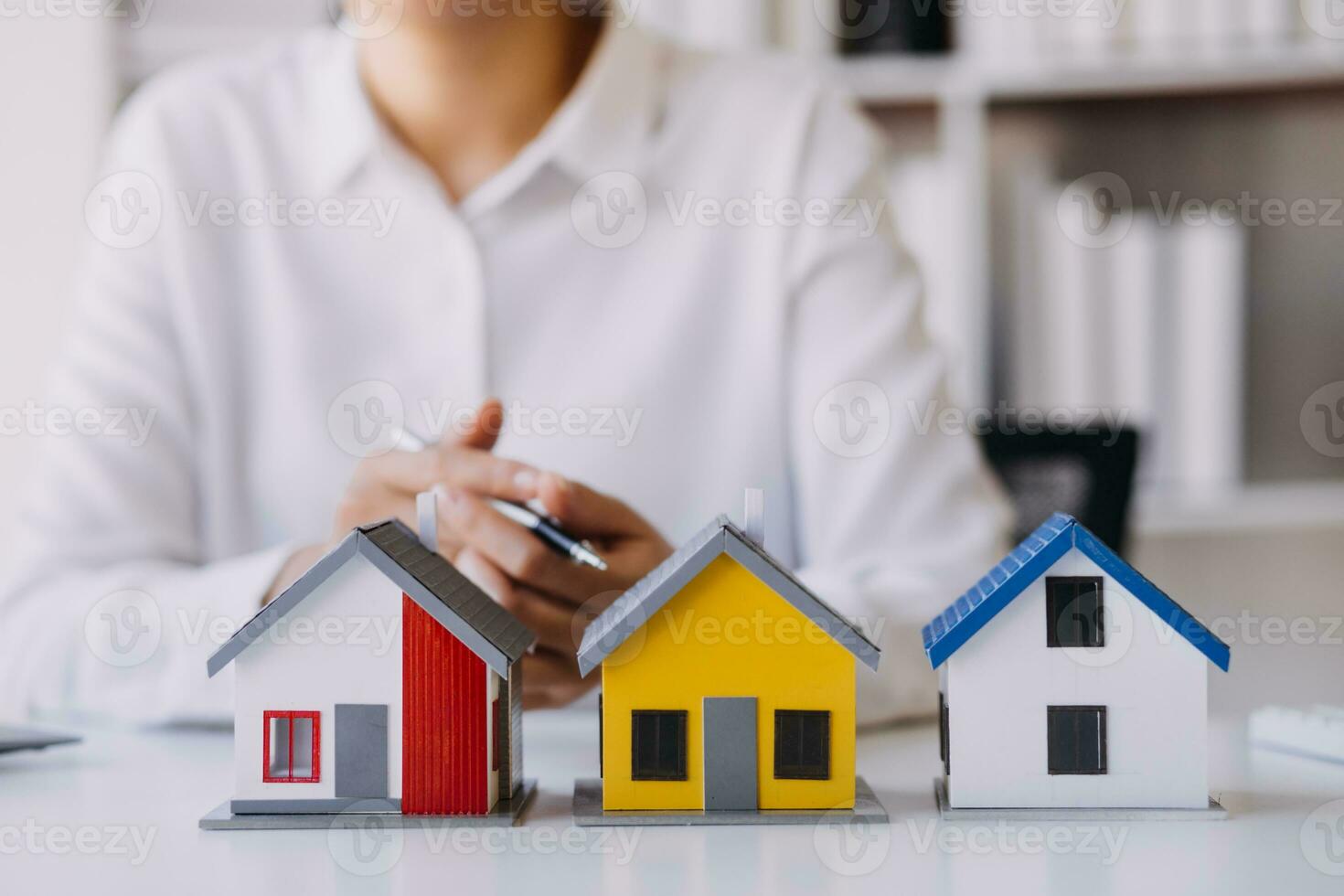 A couple is approaching a housing project to buy, and they are discussing details and advice with a salesperson in a housing project. Real estate trading ideas with couples. photo