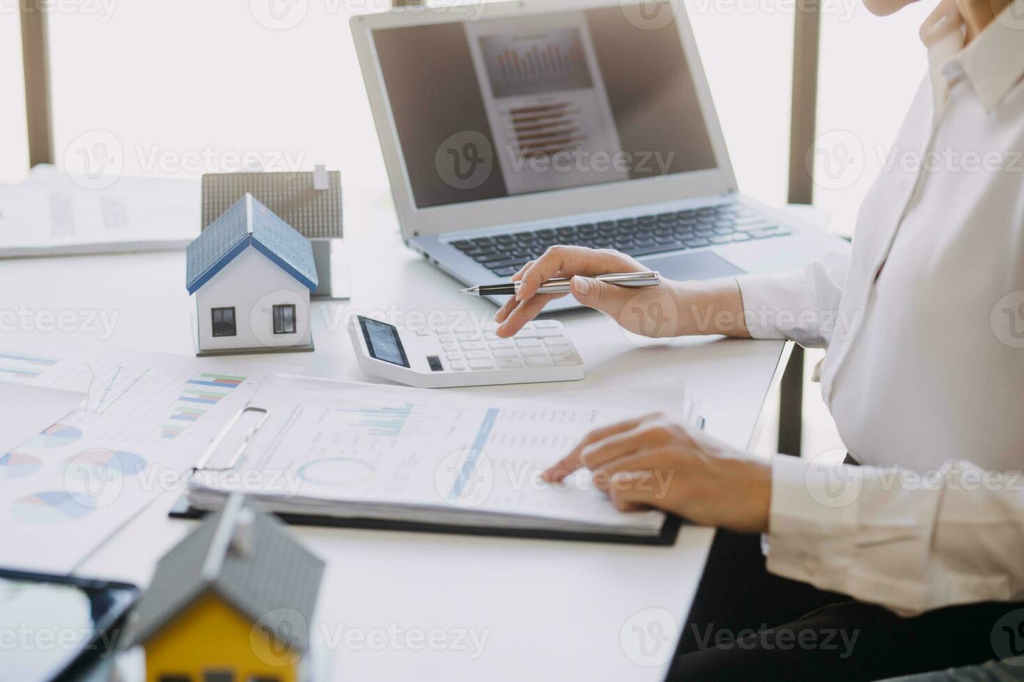 A couple is approaching a housing project to buy, and they are discussing details and advice with a salesperson in a housing project. Real estate trading ideas with couples. photo
