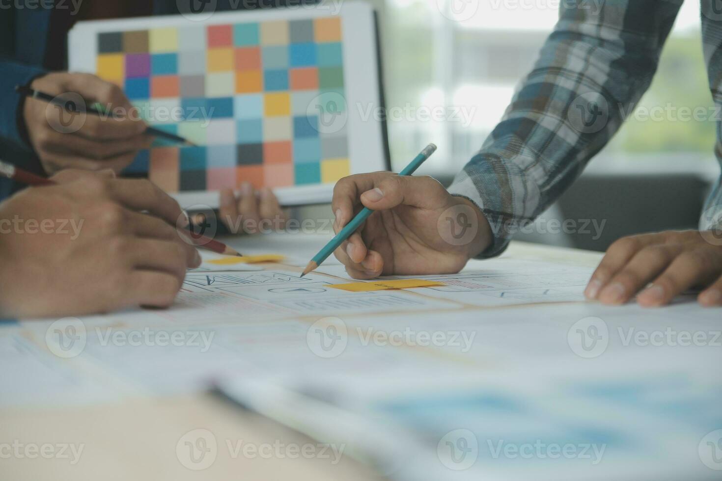 Close up ux developer and ui designer brainstorming about mobile app interface wireframe design on table with customer breif and color code at modern office.Creative digital development agency photo