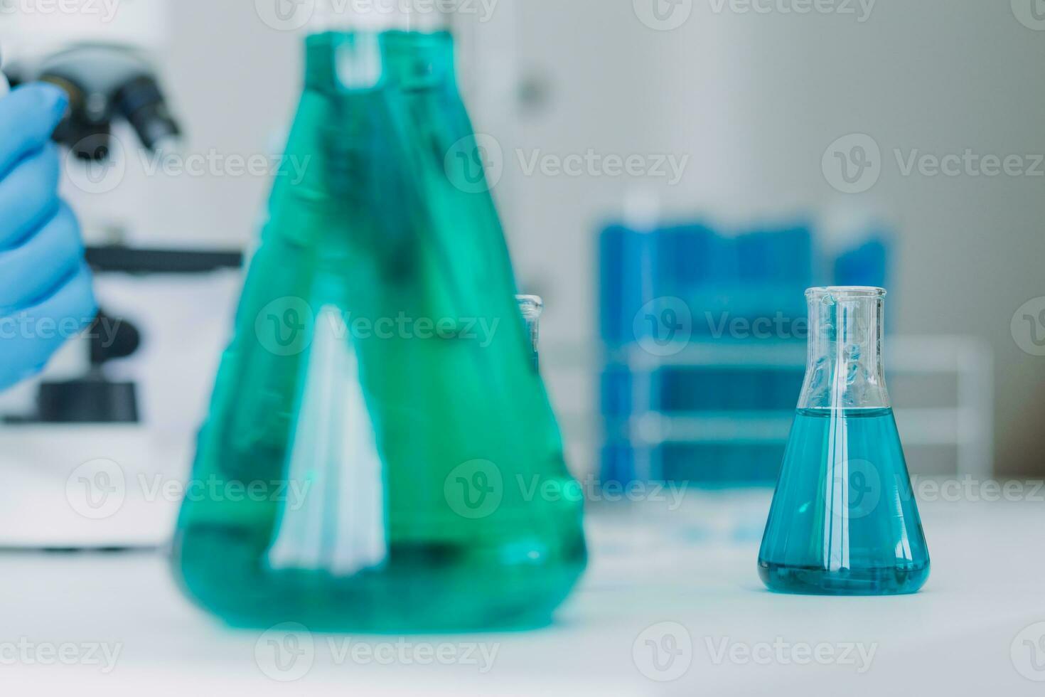 biochemical research scientist team working with microscope for coronavirus vaccine development in pharmaceutical research labolatory, selective focus photo