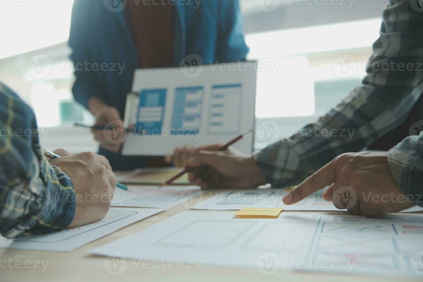 Close up ux developer and ui designer brainstorming about mobile app interface wireframe design on table with customer breif and color code at modern office.Creative digital development agency photo