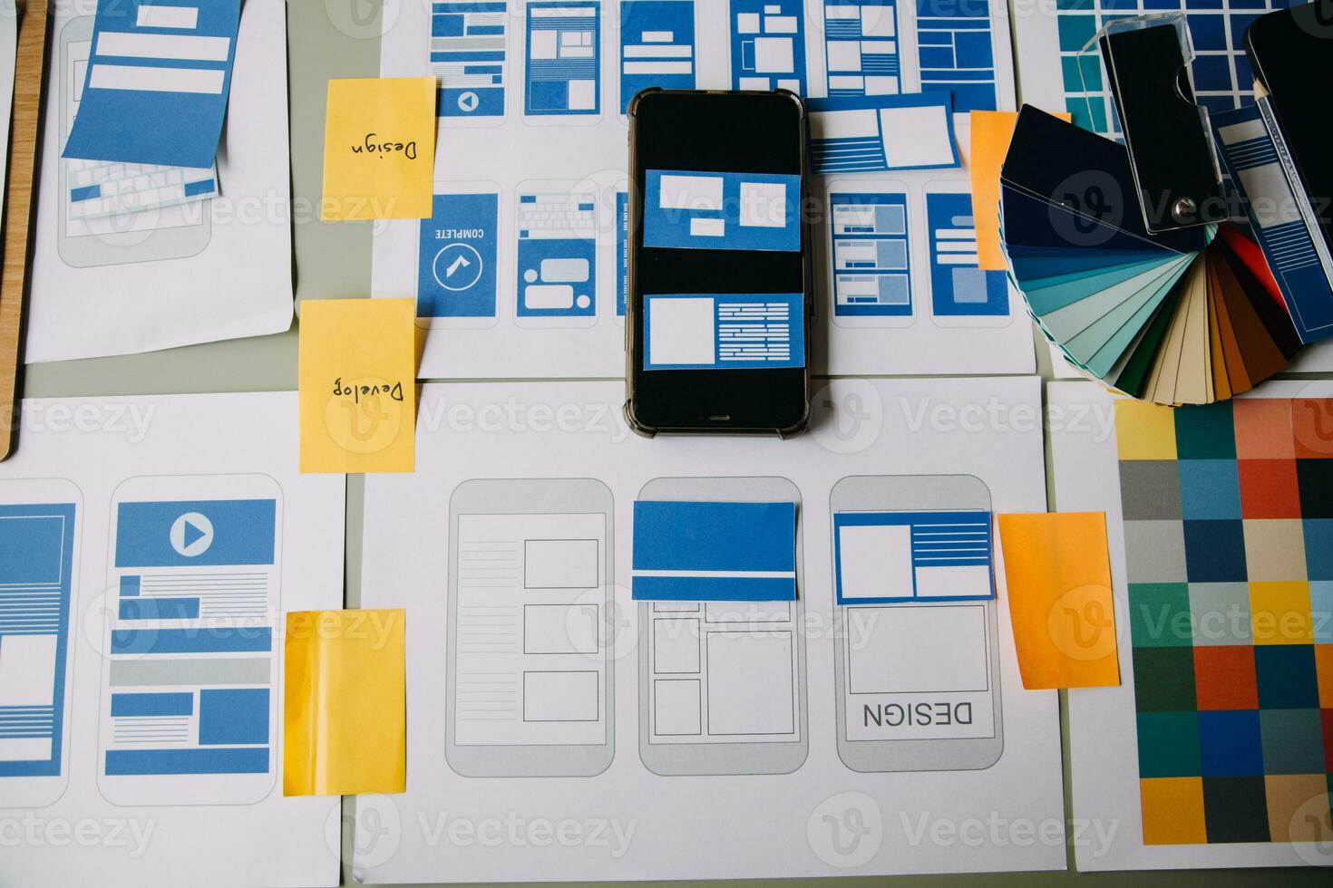 Close up ux developer and ui designer brainstorming about mobile app interface wireframe design on table with customer breif and color code at modern office.Creative digital development agency photo