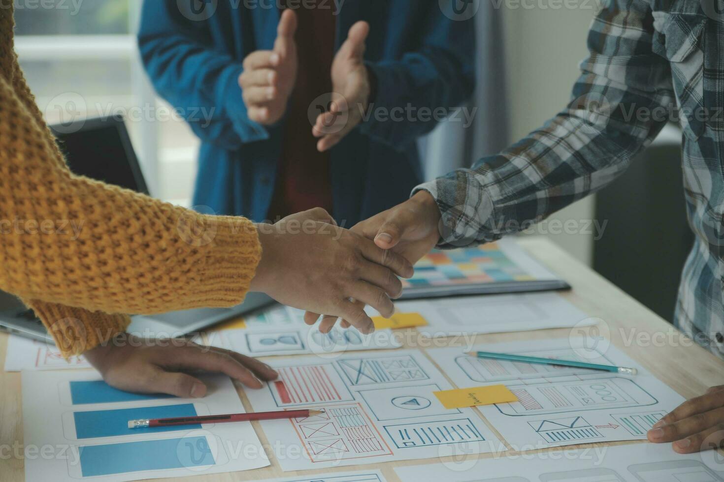 Close up ux developer and ui designer brainstorming about mobile app interface wireframe design on table with customer breif and color code at modern office.Creative digital development agency photo