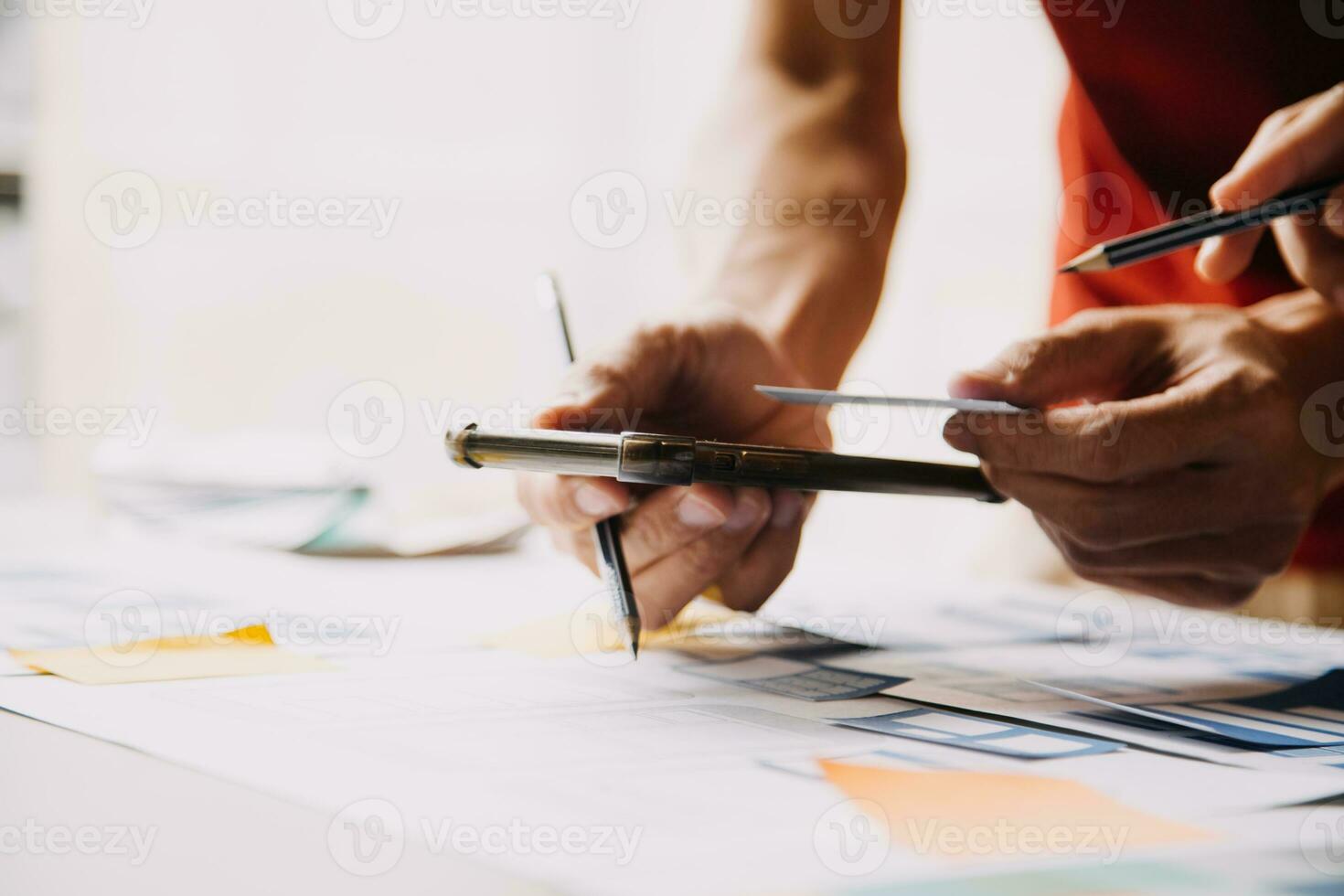 Close up ux developer and ui designer brainstorming about mobile app interface wireframe design on table with customer breif and color code at modern office.Creative digital development agency photo