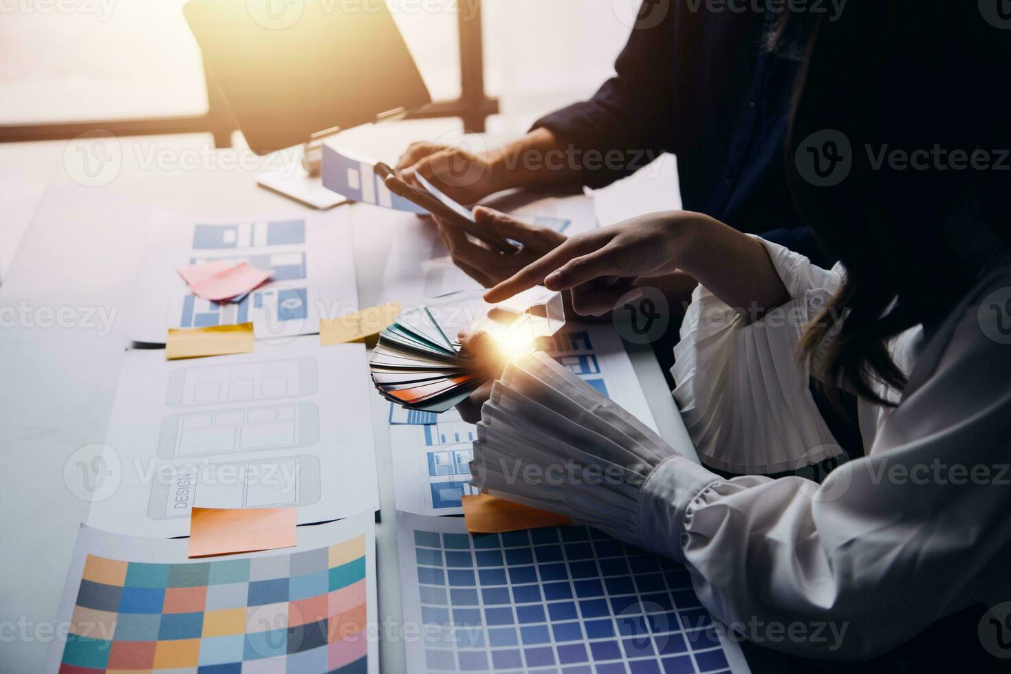 Close up ux developer and ui designer brainstorming about mobile app interface wireframe design on table with customer breif and color code at modern office.Creative digital development agency photo