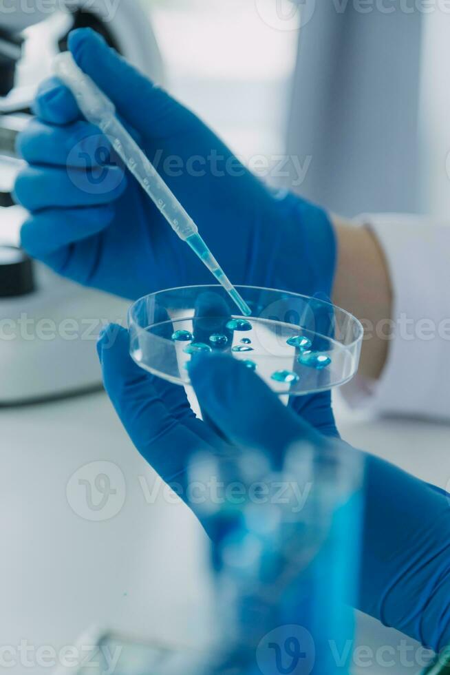 biochemical research scientist team working with microscope for coronavirus vaccine development in pharmaceutical research labolatory, selective focus photo