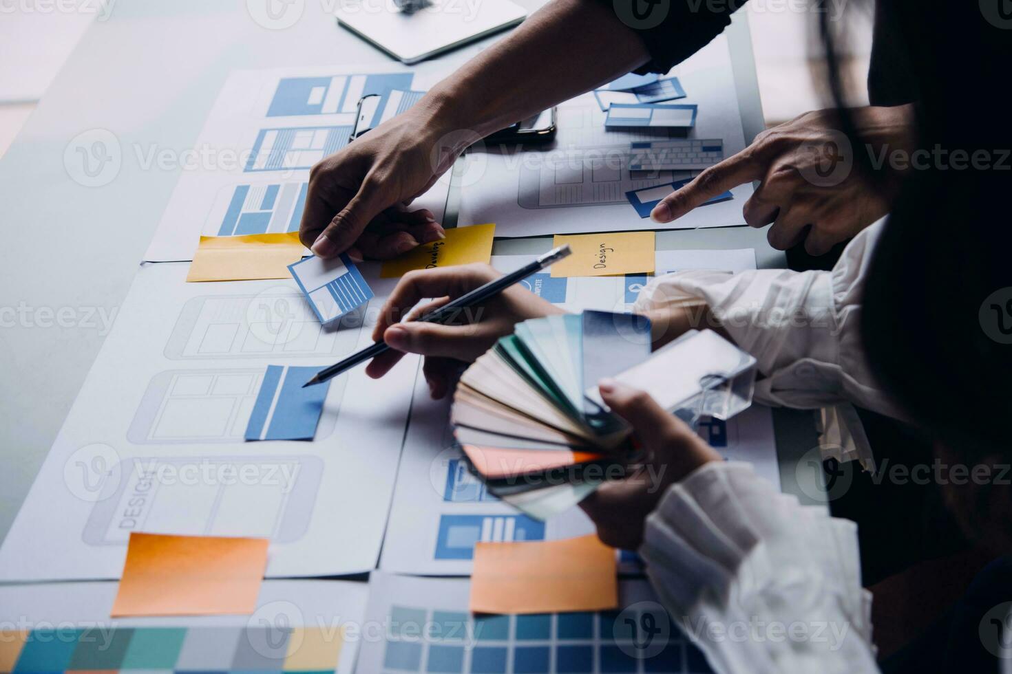 Close up ux developer and ui designer brainstorming about mobile app interface wireframe design on table with customer breif and color code at modern office.Creative digital development agency photo