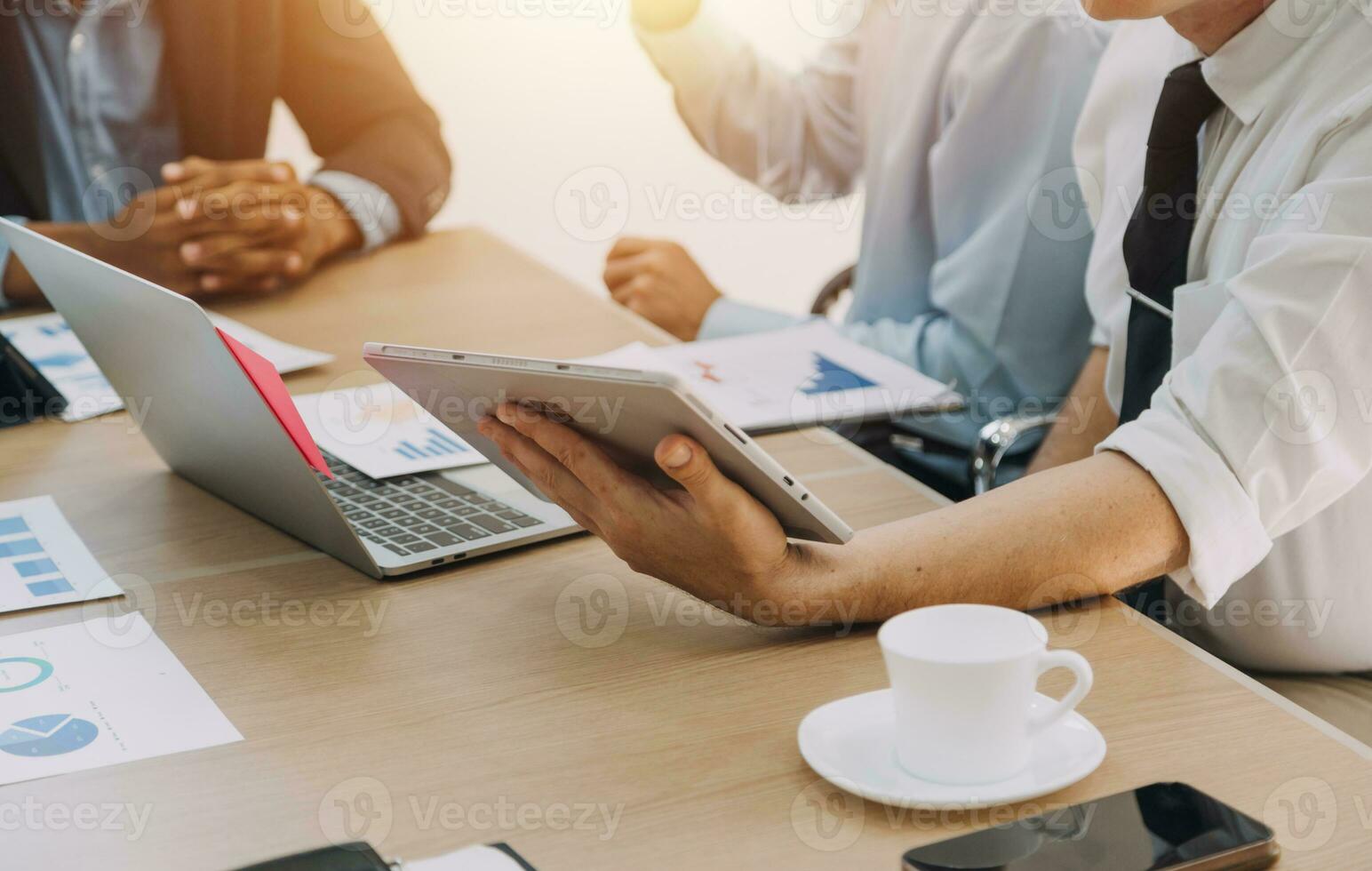 Financial analysts analyze business financial reports on a digital tablet planning investment project during a discussion at a meeting of corporate showing the results of their successful teamwork. photo