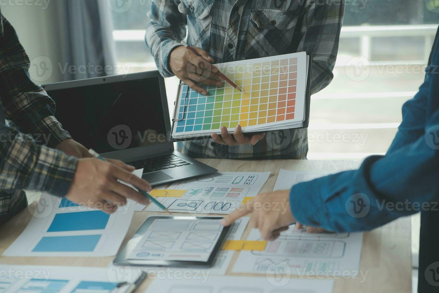 Close up ux developer and ui designer brainstorming about mobile app interface wireframe design on table with customer breif and color code at modern office.Creative digital development agency photo