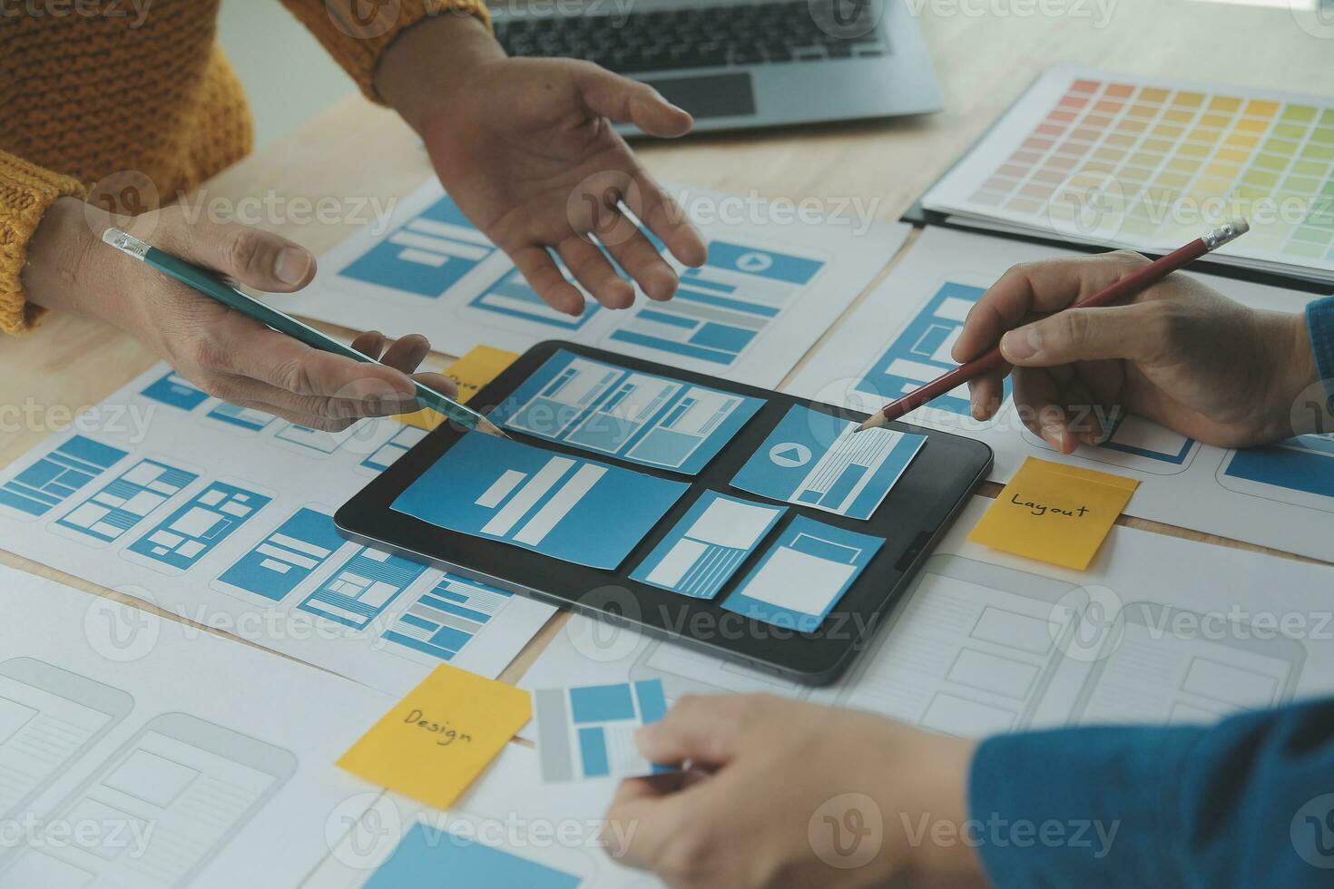 Close up ux developer and ui designer brainstorming about mobile app interface wireframe design on table with customer breif and color code at modern office.Creative digital development agency photo