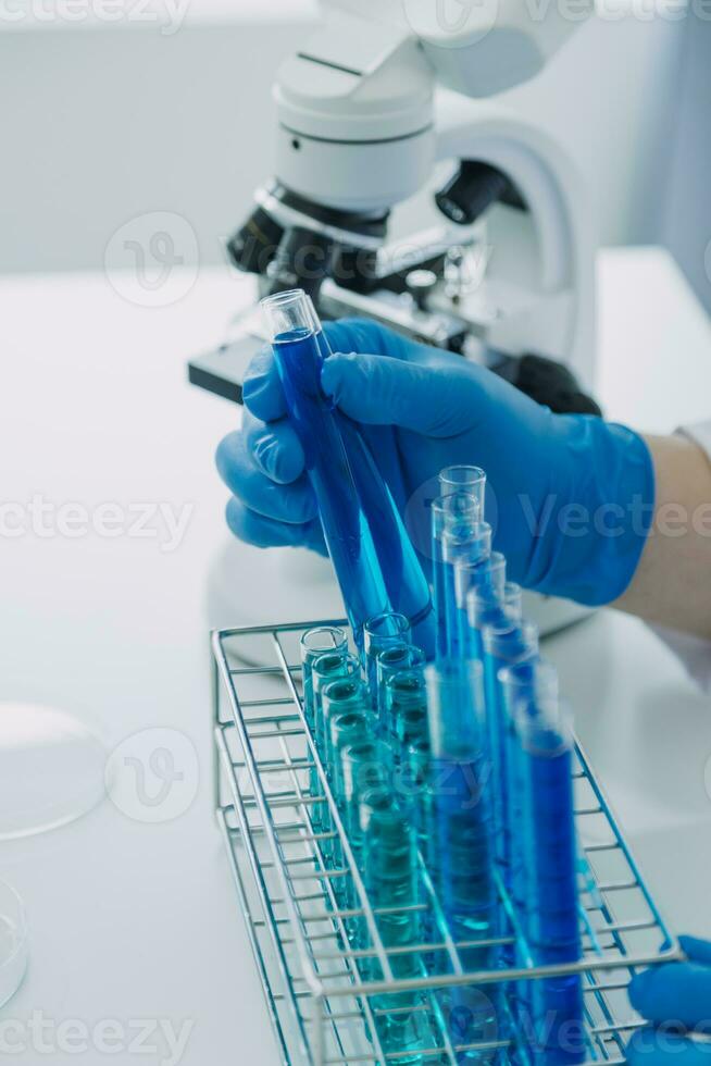 equipo científico de investigación bioquímica que trabaja con microscopio para el desarrollo de vacunas contra el coronavirus en laboratorios de investigación farmacéutica, enfoque selectivo foto