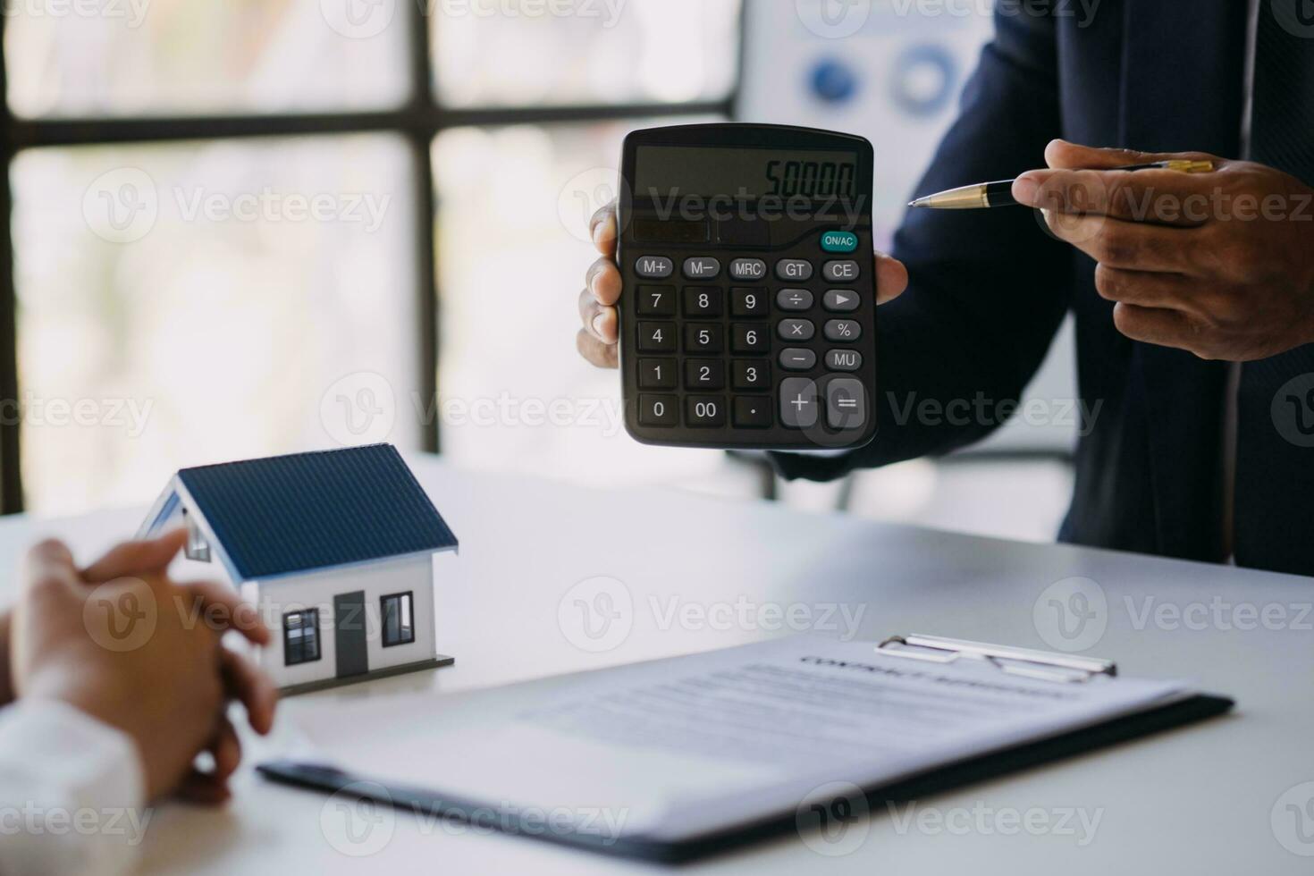 A couple is approaching a housing project to buy, and they are discussing details and advice with a salesperson in a housing project. Real estate trading ideas with couples. photo