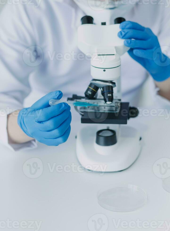 equipo científico de investigación bioquímica que trabaja con microscopio para el desarrollo de vacunas contra el coronavirus en laboratorios de investigación farmacéutica, enfoque selectivo foto