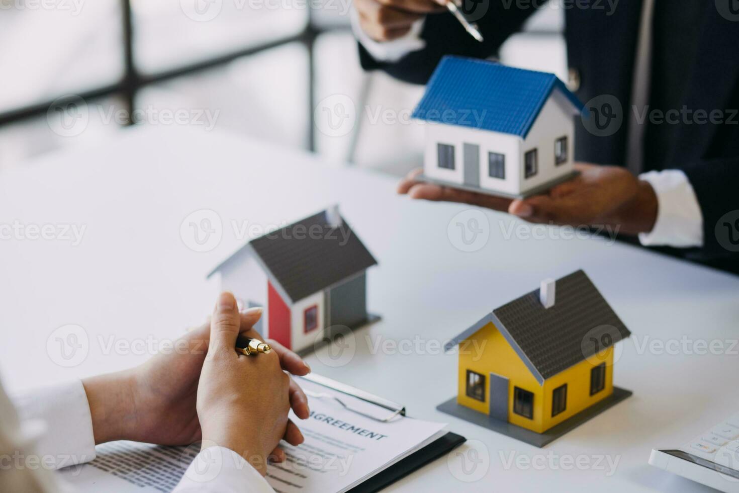 A couple is approaching a housing project to buy, and they are discussing details and advice with a salesperson in a housing project. Real estate trading ideas with couples. photo