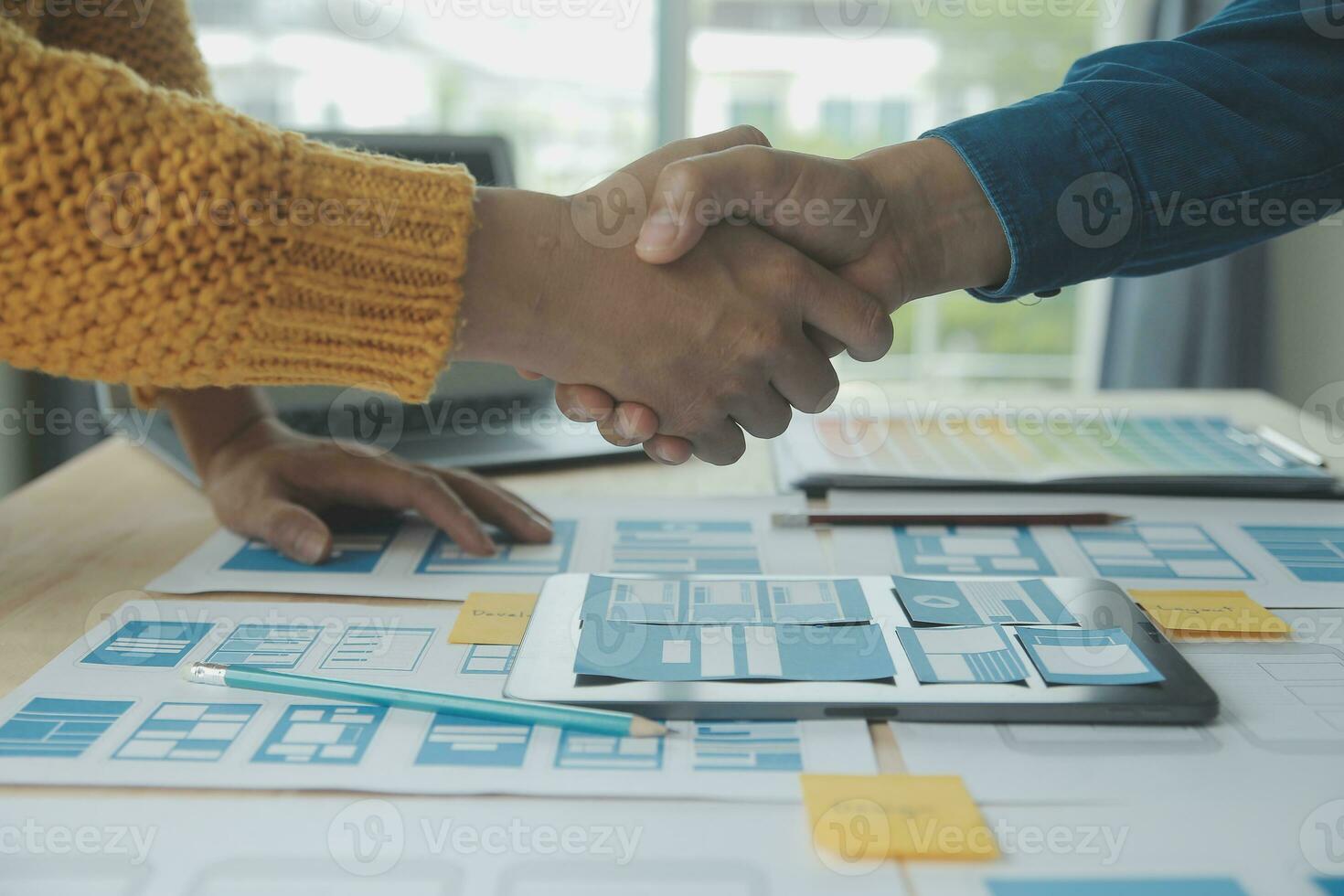 Close up ux developer and ui designer brainstorming about mobile app interface wireframe design on table with customer breif and color code at modern office.Creative digital development agency photo
