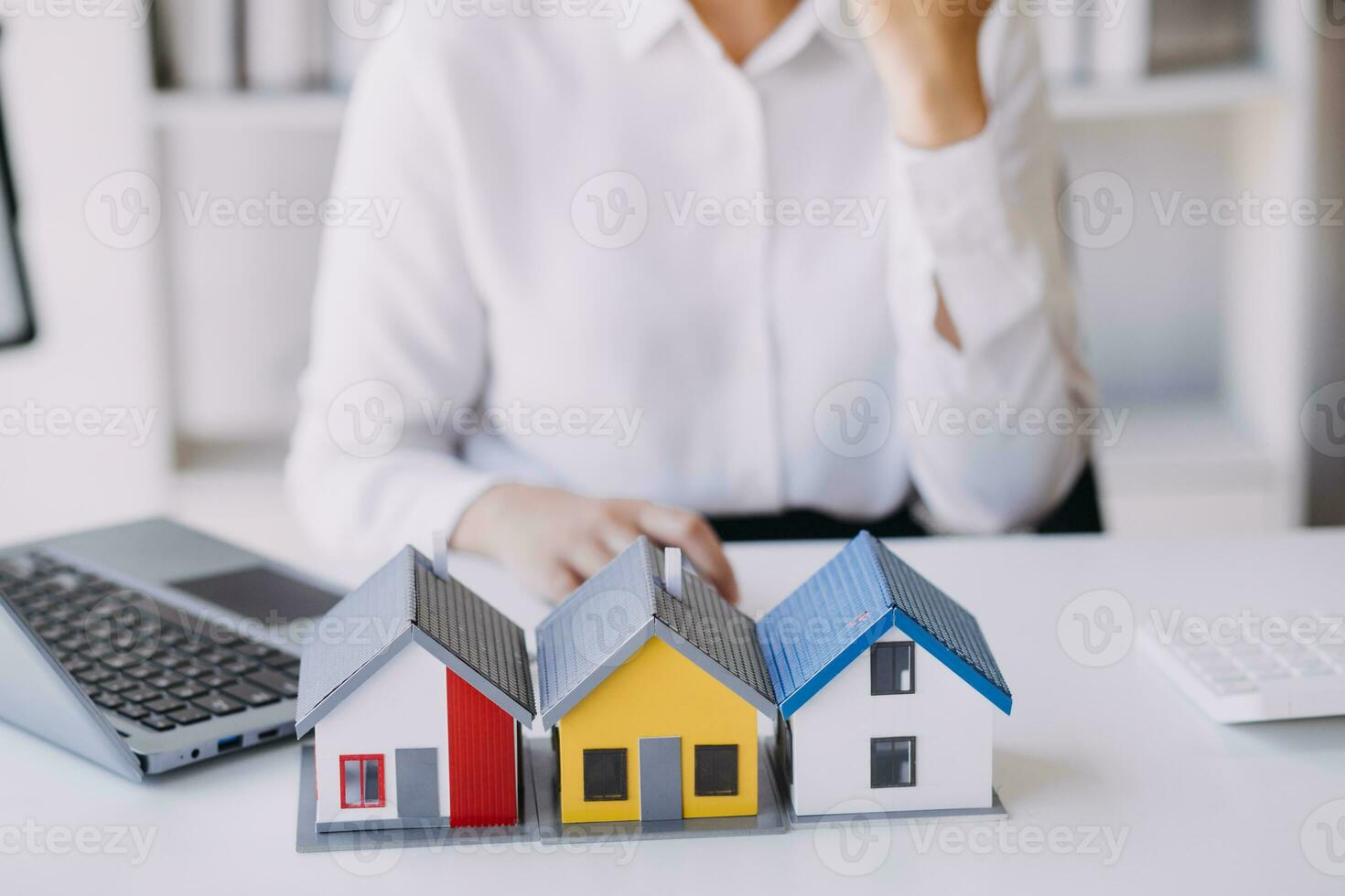 A couple is approaching a housing project to buy, and they are discussing details and advice with a salesperson in a housing project. Real estate trading ideas with couples. photo