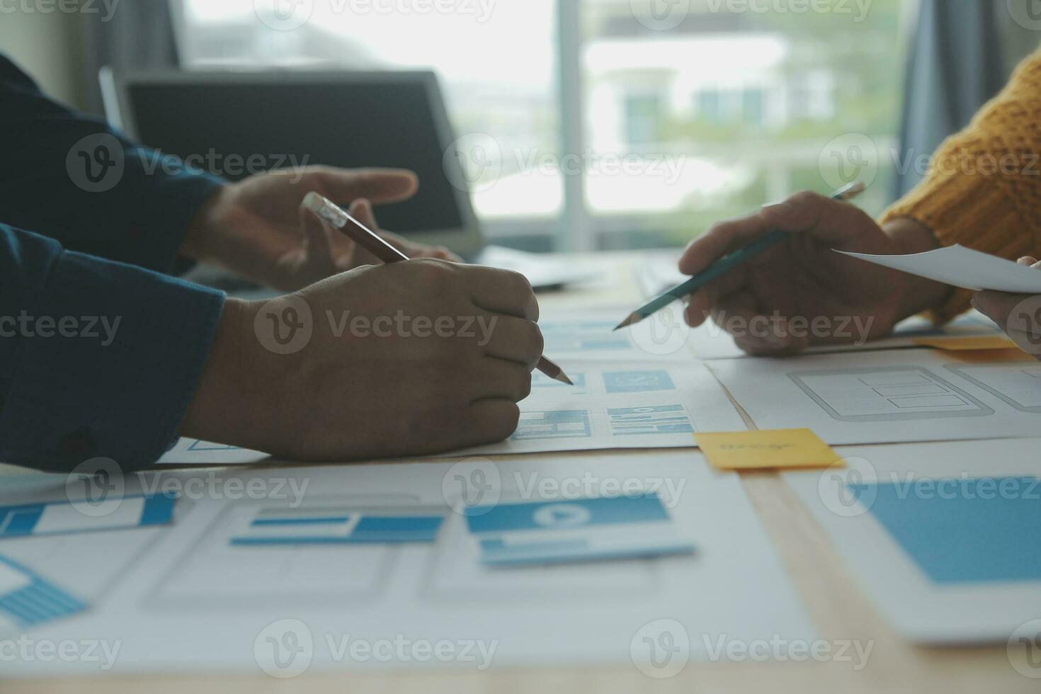 Close up ux developer and ui designer brainstorming about mobile app interface wireframe design on table with customer breif and color code at modern office.Creative digital development agency photo