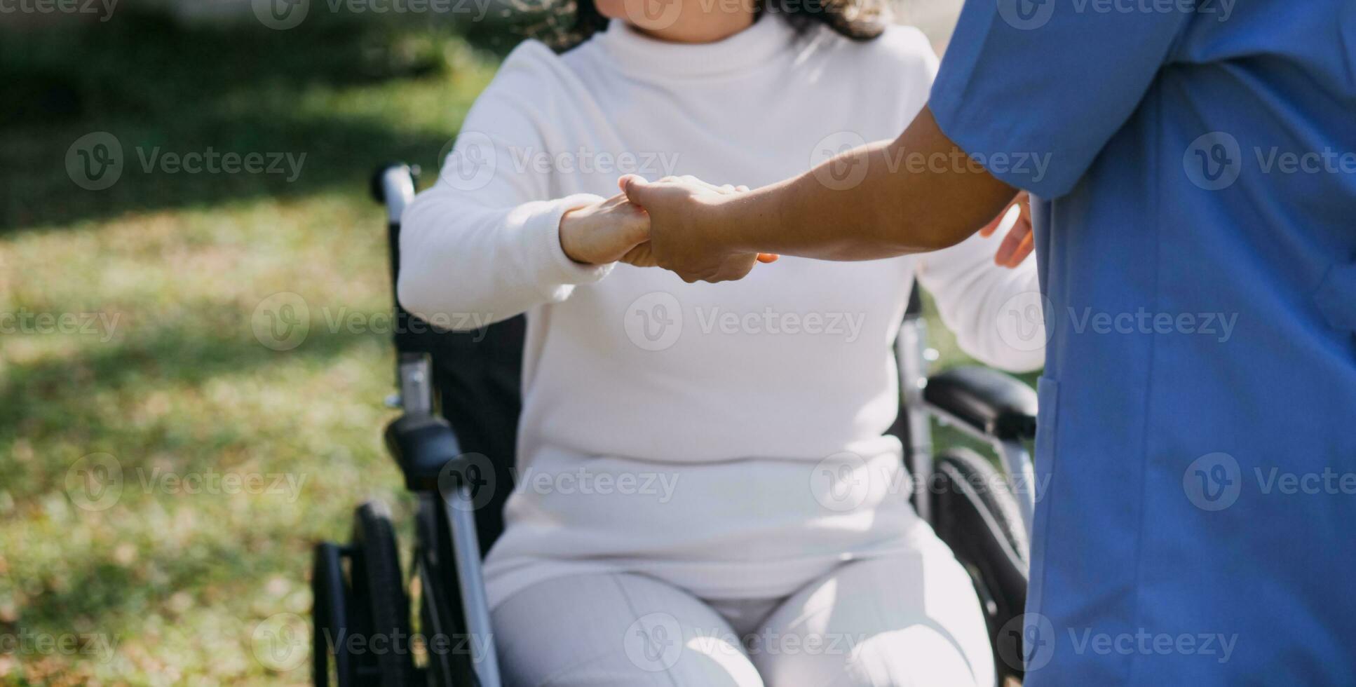 young asian physical therapist working with senior woman on walking with a walker photo