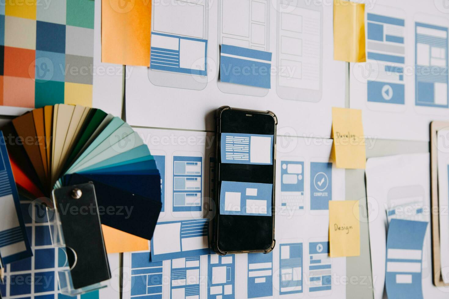 Close up ux developer and ui designer brainstorming about mobile app interface wireframe design on table with customer breif and color code at modern office.Creative digital development agency photo