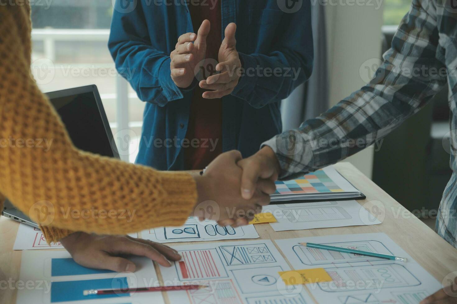 Close up ux developer and ui designer brainstorming about mobile app interface wireframe design on table with customer breif and color code at modern office.Creative digital development agency photo