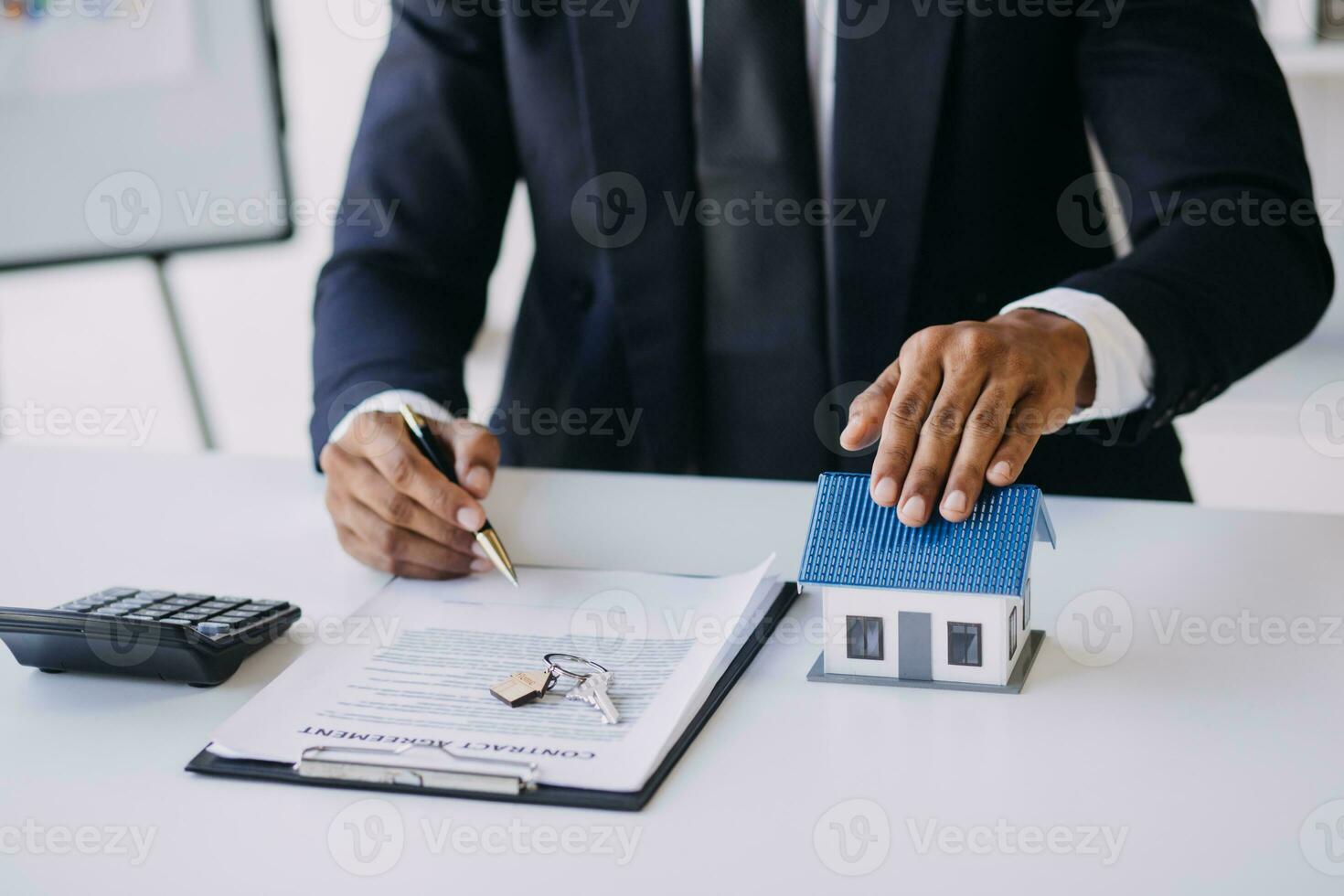 A couple is approaching a housing project to buy, and they are discussing details and advice with a salesperson in a housing project. Real estate trading ideas with couples. photo
