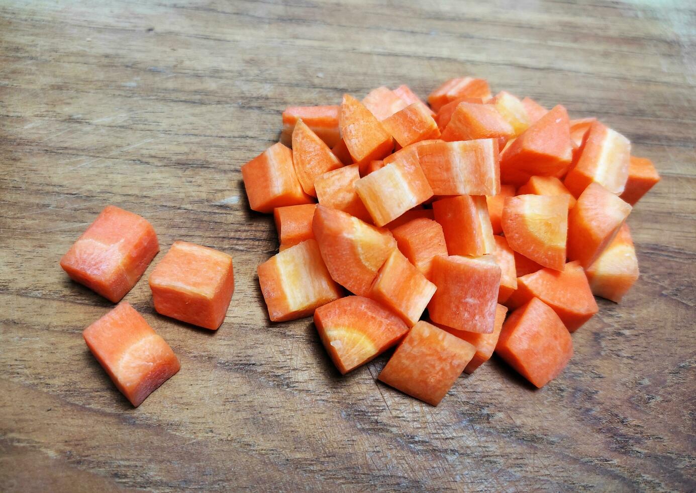 cortado en cubitos zanahorias en de madera corte tablero. foto
