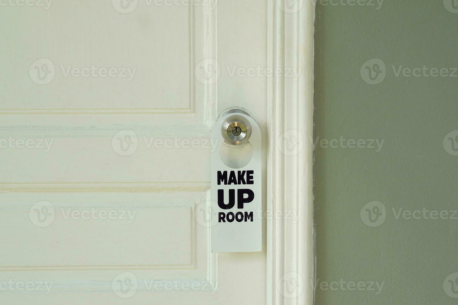 white door hanger the message says Make Up Room that hotel guests hang on the doorknob outside the room. to allow housekeepers to come and clean the room. photo