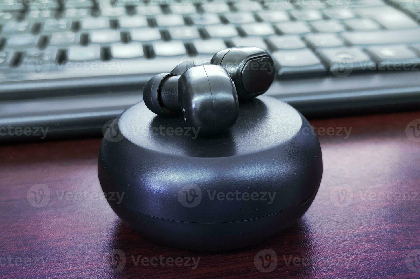 A black headphone mockup sits on a desk next to a keyboard,  black Bluetooth headphones mockup photo