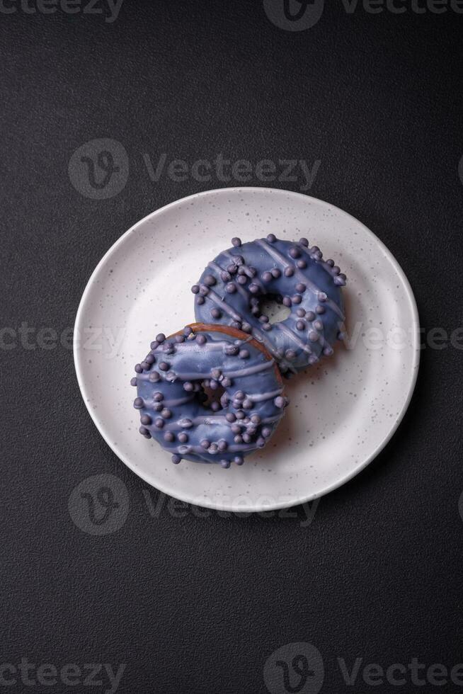 Delicious sweet donut of purple color in glaze and with lilac balls photo