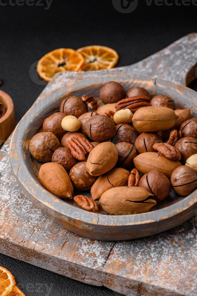 Mix of roasted macadamia nuts, cashews, pecans, almonds, raisins and dry berries photo