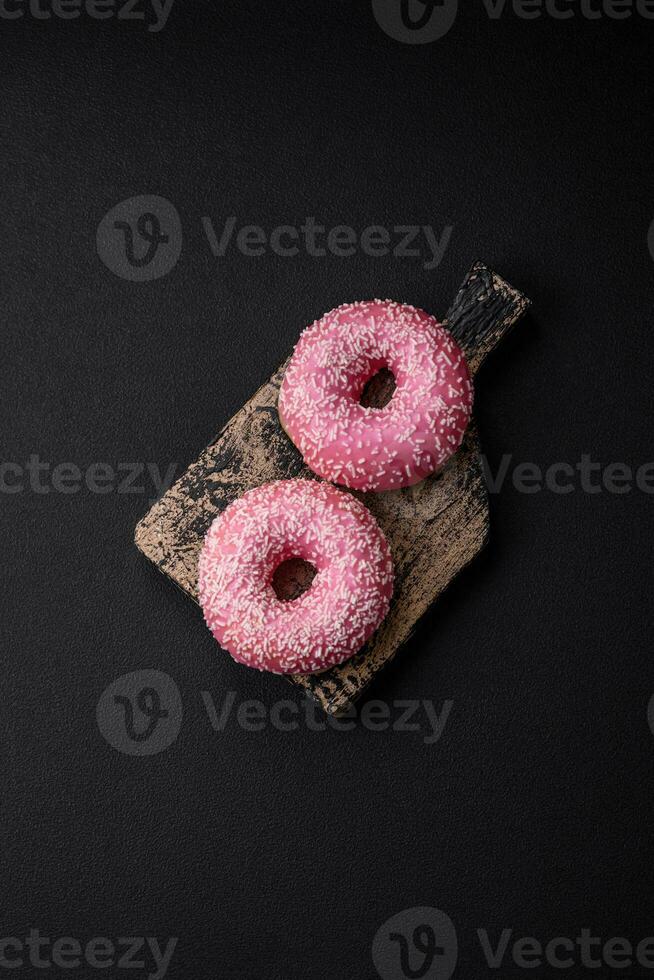 Delicious fresh sweet donuts in pink glaze with strawberry filling photo