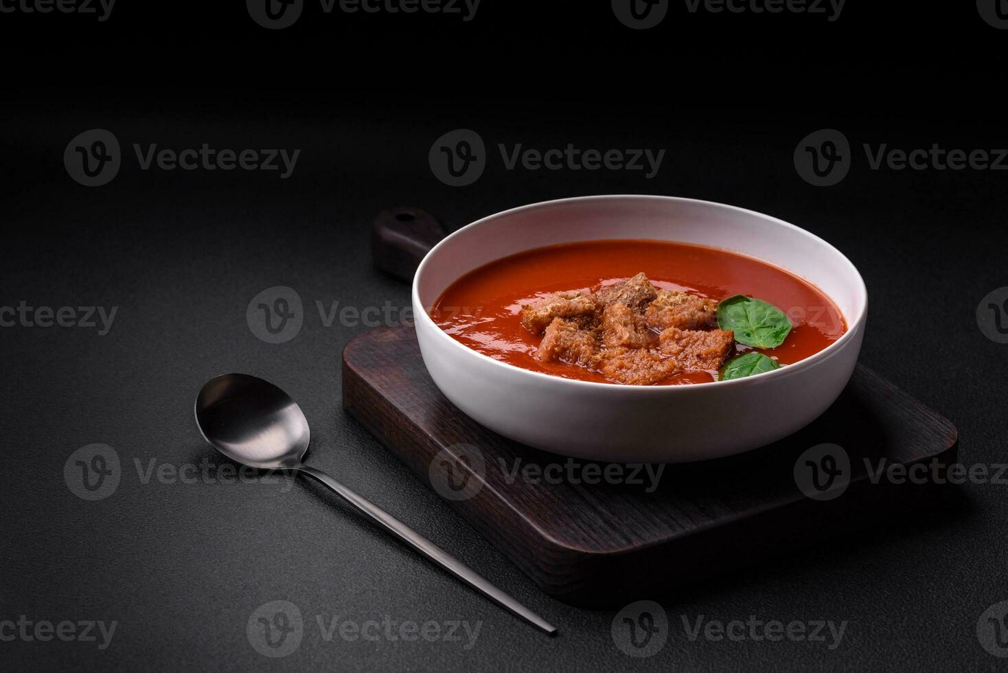 Delicious fresh gazpacho with breadcrumbs, salt and spices in a ceramic plate photo