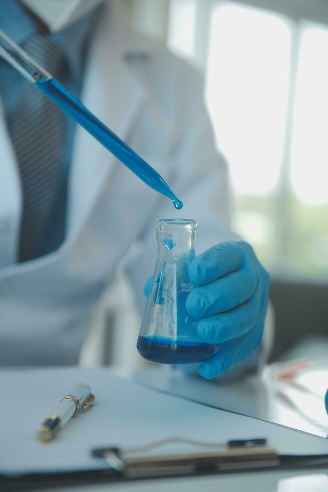 biochemical research scientist team working with microscope for coronavirus vaccine development in pharmaceutical research labolatory, selective focus photo