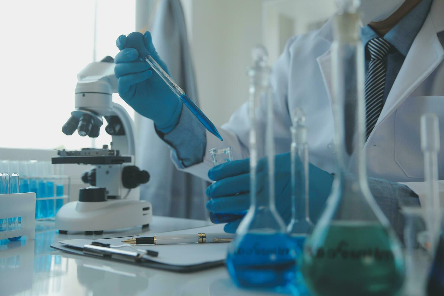 equipo científico de investigación bioquímica que trabaja con microscopio para el desarrollo de vacunas contra el coronavirus en laboratorios de investigación farmacéutica, enfoque selectivo foto