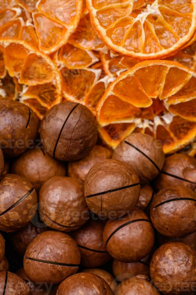 Delicious roasted macadamia nuts in shell on a dark textured background photo